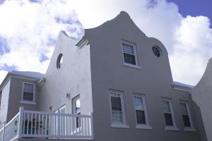 PembrokeCavendish Heights Suites的白色的大房子,有白色的围栏