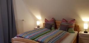 舍瑙Ferienhaus Dorfschmiede的一间卧室配有带色彩缤纷枕头的床