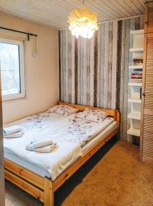 OsiekDom letniskowy Bory Tucholskie的一间卧室配有一张带白色床单的大床