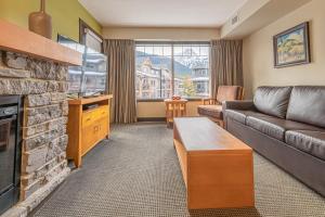 坎莫尔Copperstone Resort - Mountain View 2 Bedroom Condo的带沙发和壁炉的客厅