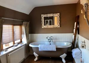 达文特里Catesby Barn Farm B&B的一间带大浴缸和镜子的浴室