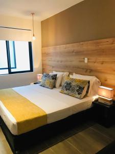 麦德林HOTEL CASA MAYOR LA 70的一间卧室配有一张大床和木制床头板