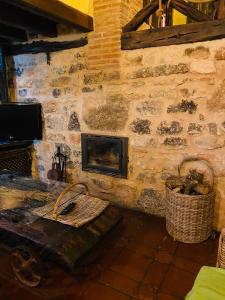 AguileraCasa rural La Antigua Vaqueria的客厅设有带壁炉的石墙
