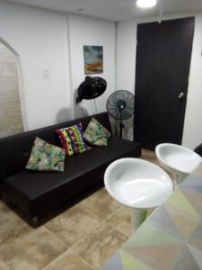 哥伦比亚港Villa mar的客厅配有黑色沙发和桌子