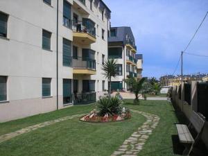巴雷罗斯Apartamento Playa Catedrales的公寓大楼前方设有花园