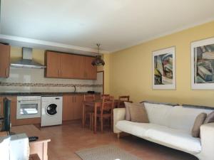 巴雷罗斯Apartamento Playa Catedrales的一间带白色沙发的客厅和一间厨房