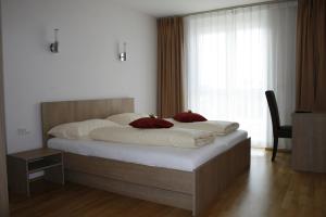 兰克韦尔大洋酒店的一间卧室配有一张大床,配有白色床单和红色枕头