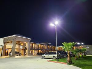 Three RiversLux Inn and Suites的晚上在酒店前面的一个停车场
