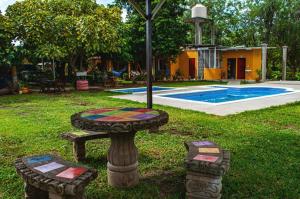 莫约加尔帕Hostal Nathaly的一个带桌子的花园和一个草地上的喷泉