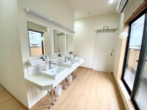 东京Upper Hotel Ryogoku的浴室设有3个水槽和2面镜子