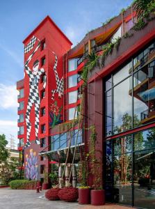 曼谷MeStyle Museum Hotel的一面是红色的建筑,一面是壁画