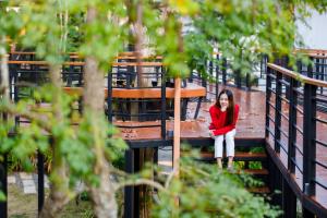 黎府普鲁阿奇瑞度假酒店的坐在木桥上的年轻女人