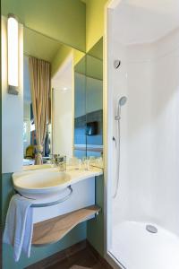 汉德维特ibis budget Flensburg Handewitt的一间带水槽、浴缸和镜子的浴室