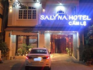 岘港Salyna Motel的晚上停在酒店门前的汽车