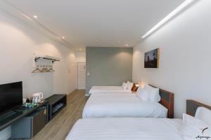 清莱Aspiraya Resort的酒店客房设有两张床和一台平面电视。