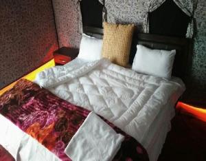 洪达尔Royal Riders Camp的一张带白色棉被和枕头的床