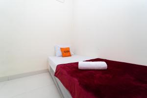 贝克西KoolKost @ Harapan Indah的白色的客房配有带橙色枕头的床