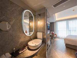 杭州杭州西湖美居酒店的一间带水槽、床和镜子的浴室