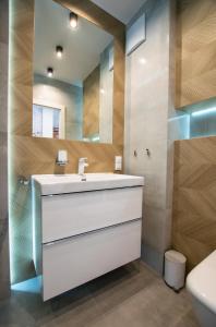 弗罗茨瓦夫Apartament Małopanewska Wrocław Centrum的浴室设有白色水槽和镜子