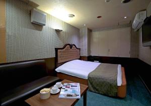 四日市Hotel Mio Resort ( Adult Only)的客房设有床、沙发和桌子。