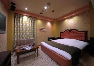 四日市Hotel Mio Resort ( Adult Only)的一间卧室配有一张大床和一张桌子