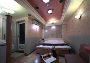 四日市Hotel Mio Resort ( Adult Only)的一间带一张床铺的卧室,位于一个带沙发的房间