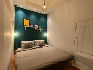 日惹Wonderloft Hostel Jogja的一间卧室配有一张蓝色墙壁的床