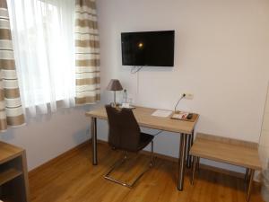 霍夫Hotel Munzert的一张桌子、椅子和墙上的电视