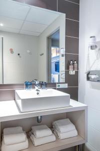 斯特拉斯堡Hotel Kaijoo by HappyCulture的浴室配有盥洗盆、镜子和毛巾