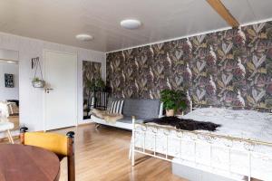 海门林纳Guesthouse Solbacka Iittala的一间卧室配有一张床,墙上贴有壁纸