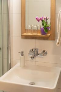 基希海姆欧瓦尔兰德酒店的浴室设有水槽、镜子和鲜花