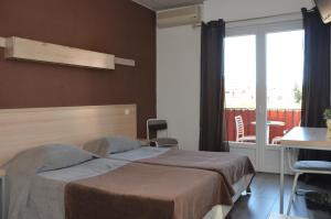 勒拉旺杜特米努斯酒店的一间卧室设有一张床、一个窗口和一张桌子