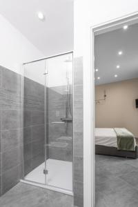 维韦罗内VIVERONE LAKE ROOMS的卧室内的玻璃淋浴间,配有床