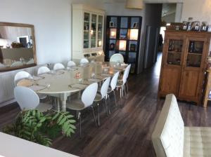布伦迪欧斯布里斯罗旅馆的一间大餐厅,配有长桌和白色椅子