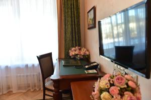 莫斯科达尼罗斯卡亚酒店的客厅配有电视和鲜花桌