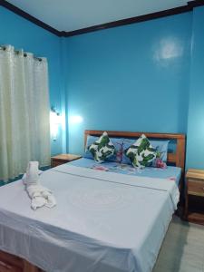 锡基霍尔Stella'z guesthouse的蓝色卧室,配有带毛巾的床