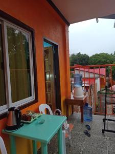 锡基霍尔Stella'z guesthouse的一个带绿桌和阳台的房子