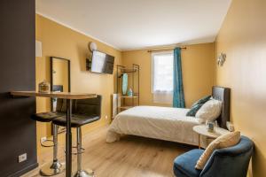 托尔西Appartements proche Paris Disney的卧室配有一张床和一张桌子及椅子