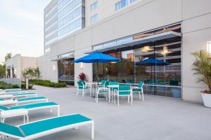 克利夫兰克利夫兰诊所假日酒店的一个带蓝白色椅子、桌子和遮阳伞的庭院