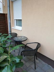 埃格尔Bodza Apartmanok的庭院里设有三把椅子和一张桌子