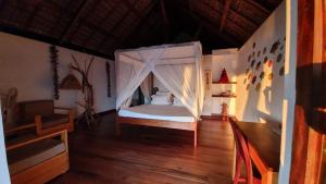 阿姆巴托洛阿卡LE TRANSAT的一间卧室配有一张带蚊帐的床