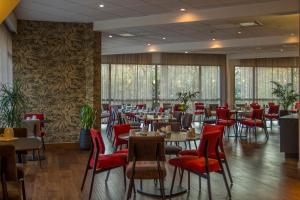 坎佩尔坎佩尔大洋洲酒店的用餐室配有桌子和红色椅子