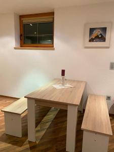 因青Ferienwohnung Sophia的一张木桌,配有葡萄酒玻璃和两把长凳