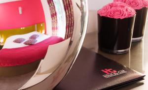 圣艾蒂安高尔夫酒店的一间设有一张粉红色床单和玫瑰床的客房