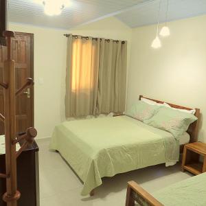 蜜岛Recanto Abayomi的一间卧室设有两张床和窗户。