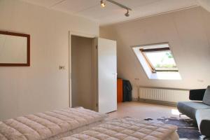 卡兰茨奥赫Appartement Abbestederweg Callantsoog的客房设有床、窗户和沙发。