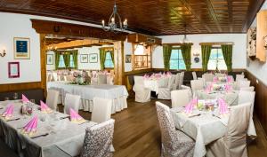PreblHotel Friesacherhof的一间设有白色桌椅和粉红色餐巾的房间