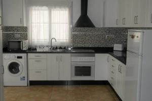 圣米格尔德萨利纳斯Casa Antony的厨房配有白色橱柜、洗衣机和烘干机