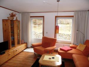 黑灵斯多夫ökologische Ferienanlage的客厅配有沙发、两把椅子和电视