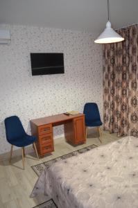 Vita-PochtovayaMotel Chalet的一间卧室配有书桌、两把椅子和一张床